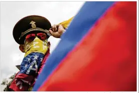  ?? WIL RIERA / ASSOCIATED PRESS ?? An anti-government demonstrat­or in a Russian military hat covers his face with a Venezuelan flag as he protests the government of President Nicolas Maduro in Caracas, Venezuela, on Sunday.