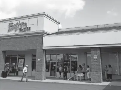  ?? PHOTOS BY BARBARA J. PERENIC/THE COLUMBUS DISPATCH ?? Customers line up outside Easton Shoes, an iconic shoe store on Henderson Road whose final sale started on Monday.