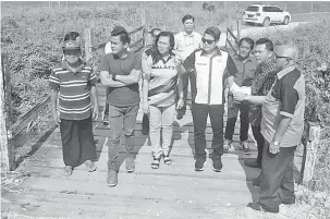  ??  ?? TURUN PADANG: Dr Rayong mendengar penerangan daripada Steward (dua kanan) berkenaan jambatan lama sambil diperhatik­an Willie (kanan) serta yang lain di Sebangkoi, semalam.