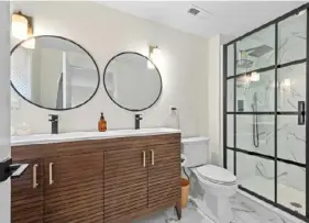  ?? ?? One second-floor bathroom has a unique double-sink vanity.
