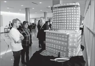  ?? [ADAM CAIRNS/ DISPATCH] ?? Downtown Hilton hotel pastry chef Aaron Clouse, left, shows off a cake resembling an artist’s rendering of the proposed second building at the Greater Columbus Convention Center on Monday. The cake was made with 150 pounds of Rice Krispies, 60 pounds...