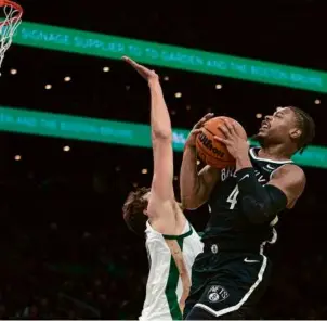  ?? TANNER PEARSON FOR THE GLOBE ?? Brooklyn’s Dennis Smith Jr. finds his path to the rim obstructed by the defensive presence of the Celtics’ 7-foot-2-inch Luke Kornet.