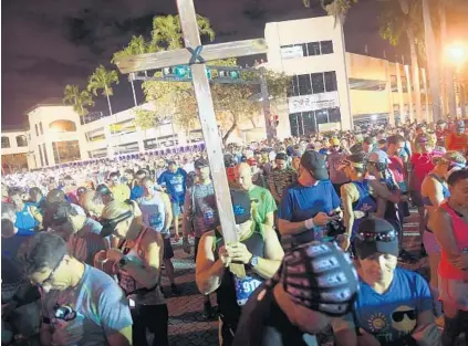  ?? PHOTOS BY JOE CAVARETTA/STAFF PHOTOGRAPH­ER ?? Some of the 6,000 runners in Sunday’s marathon observe a moment of silence for the victims of the Douglas High school shooting.