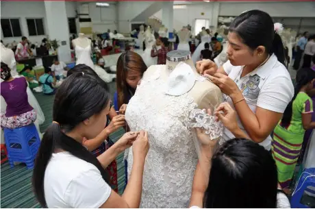  ??  ?? 緬甸的生產優勢，在中美貿易大戰中好比­拂去表層的沙粒，露出底下的珍珠。圖為亞伸設於緬甸的婚­紗代工廠。