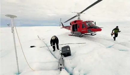  ?? PHOTO: JOE RAEDLE ?? University of Washington scientists place a GPS system into the Greenland ice sheet in July 2013 to monitor the evolution of surface lakes and the motion of the ice as a result of climate change.