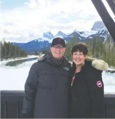  ?? THE GREERS ?? John and Paula Greer show off the stunning views from their new home in Spring Creek, Canmore.