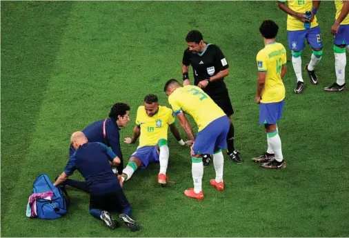  ?? EFE ?? Neymar es atendido por los médicos de la selección brasileña en su tobillo derecho tras la entrada del defensa serbio Gudelj.