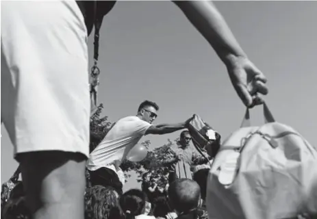  ?? AAron Ontiveroz, The Denver Post ?? Colorado Rockies pitcher Kyle Freeland hands out backpacks and school supplies to students on the playground at Holm Elementary during a surprise visit Friday.