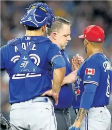  ?? MIKE STOBE/GETTY IMAGES ?? Marcus Stroman, right, is attended to in the fifth inning against the New York Yankees at Yankee Stadium on Monday. Stroman was pulled from the game after 79 pitches because of a developing blister. The starter is blaming the MLB for the current...