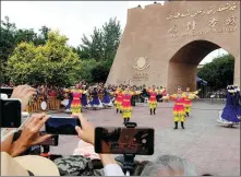  ?? MA KAI / XINHUA ?? An ethnic dance is performed in front of the Ancient City of Kashgar scenic area in the Xinjiang Uygur autonomous region to welcome tourists from around the country on Friday.