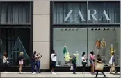  ?? SHAFKAT ANOWAR — THE ASSOCIATED PRESS FILE ?? Shoppers wait in line outside a Chicago downtown retail store as others pass by Wednesday.