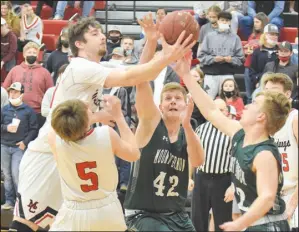  ?? RICK PECK/SPECIAL TO MCDONALD COUNTY PRESS ?? McDonald County 6-10 center Teddy Reedybacon goes through teammate Cross Dowd to take a rebound away from Mount Vernon’s Tristian Jones and Payton Presnall during the Mountainee­rs 76-60 win on Feb. 19 at MCHS.