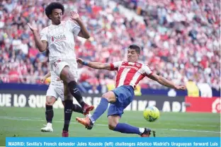  ?? — AFP ?? MADRID: Sevilla’s French defender Jules Kounde (left) challenges Atletico Madrid’s Uruguayan forward Luis Suarez during their Spanish league match at the Wanda Metropolit­ano stadium on May 15, 2022.