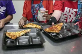  ?? ALBERTO MARIANI — THE ASSOCIATED PRESS FILE ?? Second-grade students select their meals during lunch break in the cafeteria at an elementary school in Scottsdale, Ariz., on Dec. 12.