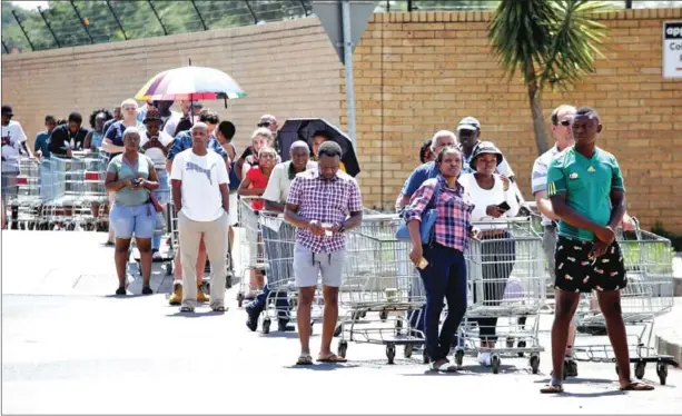  ?? AFP ?? Customers outside Makro in Pretoria East, South Africa. More African countries are expected to announce tough confinemen­t measures after sealing their borders.