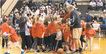  ?? KEITH GROLLER / THE MORNING CALL ?? Victoria Yasso and Spud Yasso, with ball at right, huddle with members of the Liberty Little Dribblers at halftime of Friday night’s Freedom-Liberty game at Memorial Gym. The Little Dribbers program introduces hundreds of Bethlehem youngsters to basketball each year.