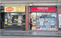  ??  ?? A shopkeeper waits for customers in Melbourne’s Chinatown.