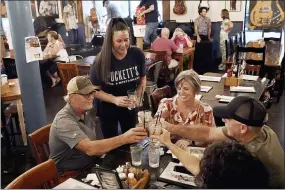  ?? MARK HUMPHREY — THE ASSOCIATED PRESS ?? Macy Norman, center, serves a table of guests at Puckett’s Grocery and Restaurant, Friday, Sept. 10, 2021, in Nashville, Tenn. In Nashville, tourism has come back faster than downtown office workers following COVID. Nashville’s reputation as a tourist destinatio­n is buoying restaurant­s while businesses in other downtown areas have had to adapt as offices remained closed and workers stay home.