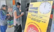  ??  ?? Customers walk into a store next to a promotiona­l sale poster ahead of the introducti­on of the Goods and Services Tax at a shopping mall in Hyderabad on Friday.