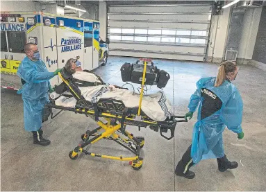  ?? RICK MADONIK PHOTOS TORONTO STAR ?? The mock scenario begins with the arrival of a patient from a long-term-care home by ambulance. Volunteer Kim Dooner plays the patient, an 84-year-old male named Henry with a suspected hip fracture and a potential COVID-19 infection.