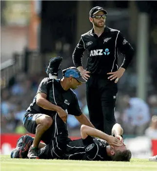  ??  ?? New Zealand physiother­apist Vijay Vallabh tends to Lockie Ferguson after he was struck down with cramp mid-over.