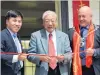  ?? PHOTO: STEVE ADDISON ?? History . . . Lawrence Chinese Camp Charitable Trust chairman Dr Jim Ng (centre) opens the historic Joss House at the camp on Saturday, assisted by Chinese Consulgene­ral Jin Zhijian (left) and Clutha Mayor Bryan Cadogan (right).