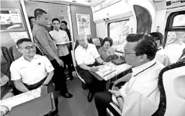  ?? - Bernama photo ?? Prime Minister Datuk Seri Najib Tun Razak and his wife Datin Seri Rosmah Mansor take a ride on the Electric Train Service (ETS) for the KL Sentral-Tanjung Malim stations route. Also present is Transport Minister Datuk Seri Liow Tiong Lai (seated right).