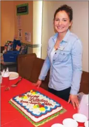  ?? LISA MITCHELL — DIGITAL FIRST MEDIA ?? Kutztown Community Library celebrated author Laura Ingalls Wilder’s 150th birthday with a birthday cake at the program “Beyond Little House” on Feb. 18. Youth Librarian Taylor Kutz prepares to cut the birthday cake for fans of the “Little House” books.