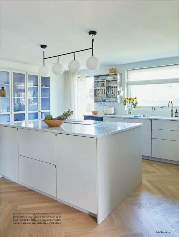  ??  ?? Køkkenet er baseret på Ikea-modulerne fra det gamle køkken. Nye låger fra Reform Cph og en smuk marmorbord­plade har dog aendret looket markant. Lampen over køkkenøen er fra Menu.