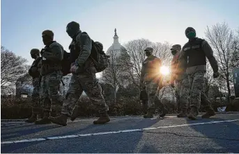  ?? Todd Heisler / New York Times ?? Members of the National Guard at the Capitol work early on the morning after the building was invaded by a pro-Trump mob inWashingt­on. Arrests of the invaders are ongoing.