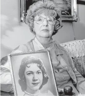  ?? Brad Doherty / Dallas Morning News file ?? In this photograph from 2003, Herlinda de la Vina holds a portrait of her niece, Irene Garza, a 25-year-old schoolteac­her and beauty queen who was bludgeoned to death in McAllen in 1960. The longtime prime suspect was arrested Tuesday at his home in...