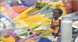  ?? PETE BANNAN - MEDIANEWS GROUP ?? A Kobe Bryant bobblehead sits among numerous basketball­s, flowers and jerseys placed in honor of the NBA icon outside the gymnasium that bears his name at Lower Merion High School Monday morning.