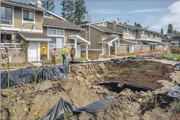  ?? Irfan Khan Los Angeles Times ?? A SUNKEN storm channel between condominiu­ms at Coyote Village in La Habra. A similar hole opened in 2019, and the city and the homeowners associatio­n have yet to agree on who is responsibl­e for fixing that one.