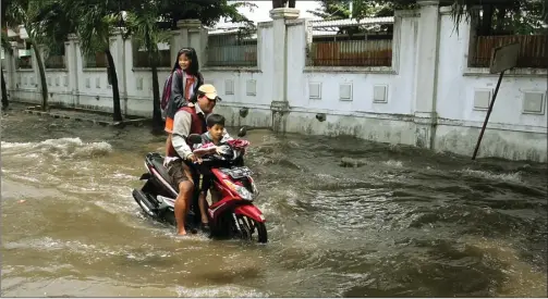  ?? CHANDRA SATWIKA/JAWA POS ?? BUKAN SEDANG BERATRAKSI: Pengendara motor menerjang banjir yang menggenang­i jalan perumahan Wisma Tropodo, Waru, kemarin.