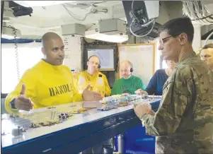  ?? AP PHOTO ?? Gen. Joseph Votel, the top U.S. commander for the Middle East, right, gets a briefing on the USS Nimitz from Lt. Cmdr. Vern Jensen, the aircraft handling officer for the ship.