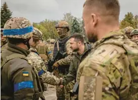  ?? NICOLE TUNG/THE NEW YORK TIMES ?? President Volodymyr Zelenskyy of Ukraine makes an unannounce­d visit to a flag raising ceremony in the main square of Izium on Wednesday.