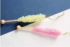  ??  ?? Old-fashioned rock candy was the inspiratio­n for Anthropolo­gie’s pink and lime glass and wood ornaments.