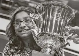  ?? Manuel Balce Ceneta photos / Associated Press ?? Ananya Vinay, 12, of Fresno, Calif., gets a trophy — and $40,000 in cash and prizes — for winning the 90th Scripps National Spelling Bee on Thursday.