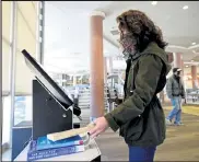  ?? Matthew Jonas / staff Photograph­er ?? Katie Corr uses the self-check out kiosk at the boulder library main branch on Tuesday.