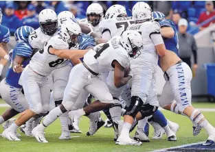  ?? MARK ZALESKI/ASSOCIATED PRESS ?? Central Florida running back Taj McGowan (4), shown scoring against Memphis earlier this season, will be looking to help the Knights to their 23rd straight victory Saturday against Cincinnati.