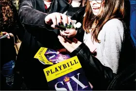  ?? (NINA WESTERVELT/THE NEW YORK TIMES) ?? People share hand sanitizer outside the Brooks Atkinson Theater in New York on March 12, 2020. Facing concern from actors and audiences about health risks during the coronaviru­s pandemic, the industry announced that shows will be shuttered through April 12.