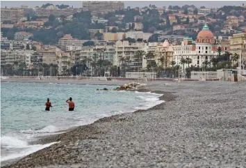  ?? — AFP ?? Two men bathe in the sea in the French riviera city of Nice during the first weekend lockdown put in place by authoritie­s to attempt to halt the spread of the Covid-19 pandemic, on Saturday.