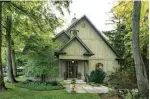  ??  ?? The detached two-storey house has a board-and-batten and stone exterior.