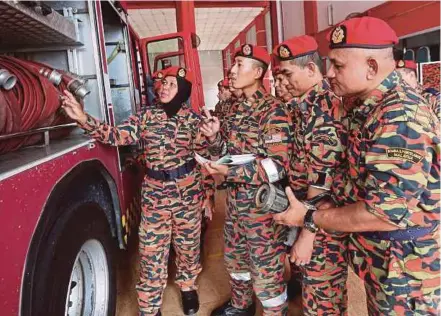  ?? [FOTO GHAZALI KORI /BH] ?? Rozizah bersama anggotanya membuat pemeriksaa­n jentera di Ibu pejabat Bomba dan Penyelamat Kuala Terengganu.