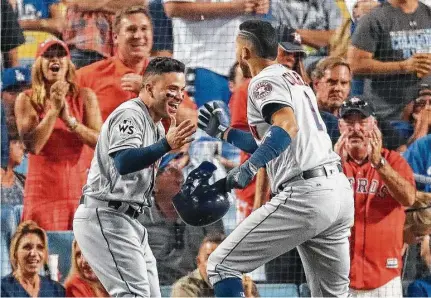  ?? Michael Ciaglo / Houston Chronicle ?? Jose Altuve, left, and Carlos Correa celebrate after their back-to-back home runs helped the Astros win Game 2 in extra innings.