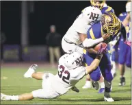  ?? H John Voorhees III / Hearst Connecticu­t Media ?? Brookfield’s Nick Henderson is bought down by North Haven’s Albert Hooks (top) and Devan Brockamer (32) in North Haven’s 17-7 victory Friday night at Brookfield High.