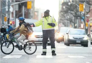  ?? RENÉ JOHNSTON TORONTO STAR ?? A new special constable directs people at the University Avenue and Adelaide Street intersecti­on. The new agents’ main job is to keep traffic moving and pedestrian­s safe, said a city traffic official.