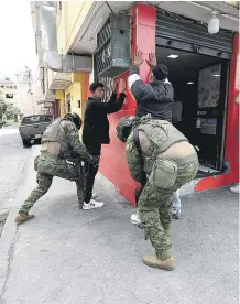  ?? EFE ?? Dos soldados cachean a dos jóvenes en Quito.