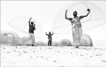  ??  ?? Afghani men carry cages used for fishing.