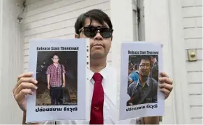  ?? — AP ?? Still missing: A Thai activist holding the portraits of Siam outside the Vietnam Embassy in Bangkok, Thailand.